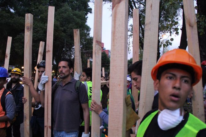 Grupo de civiles voluntarios llevan vigas de madera hacia las zonas de devastación para asistir con las labores de rescate en Ciudad de México.