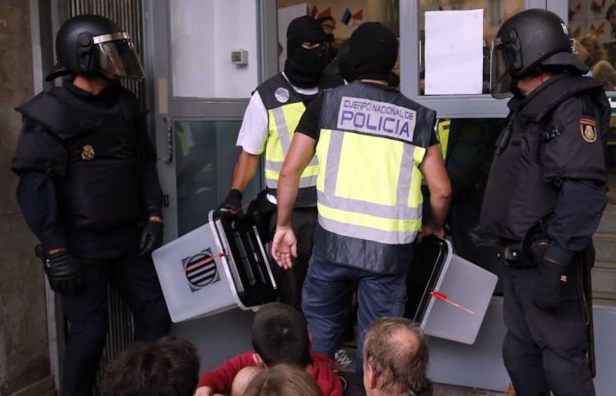 Policías españoles decomisan urnas y material electoral de un centro de votación en Barcelona.