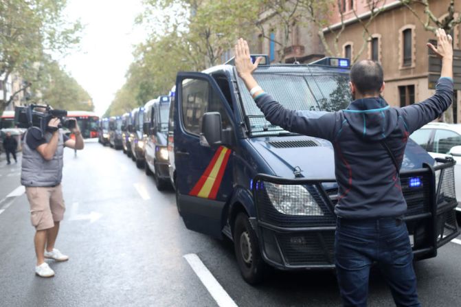 Vehículos de la policía hacen fila en una calle de Barcelona mientras tratan de controlar el área y evitar que la gente vote en el referéndum independentista considerado ilegal por el gobierno español.