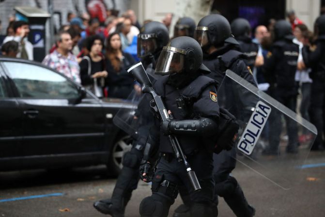 Policías antimotines en Barcelona tratan de controlar el área mientras la gente trata de votar en el referéndum por la independencia de Cataluña.