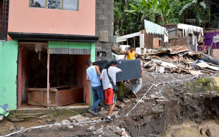 Hombres cargan un refrigerados en una zona residencial afectada por un deslizamiento tras las fuertes lluvias por Nate en Los Anonos, San José, Costa Rica, el 6 de octubre.