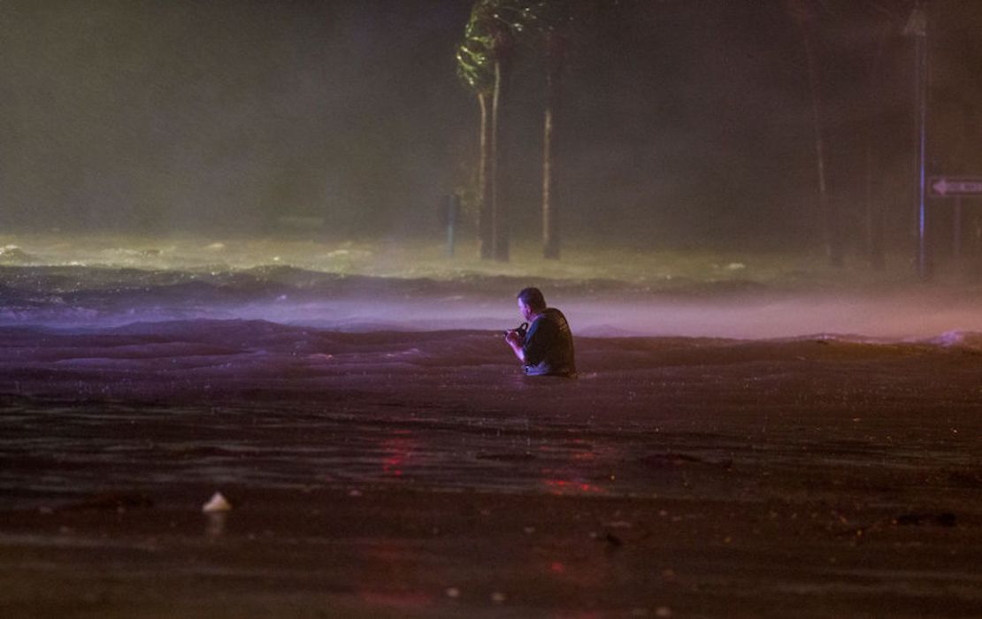 Un hombre toma fotografías en una calle inundada en Biloxi, Mississippi.