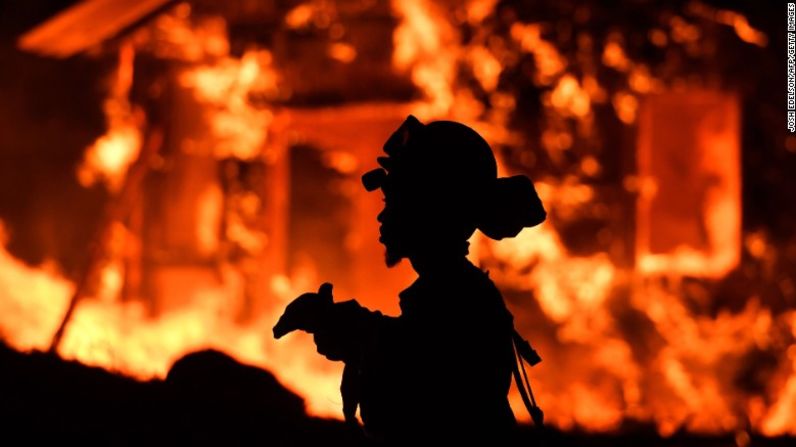 Un bombero del servicio de reos monitorea las llamas mientras una casa se incendia en Napa.