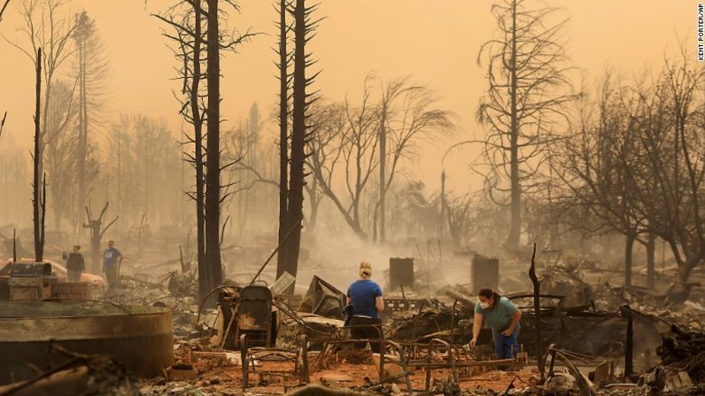 Residentes de un barrio en Santa Rosa, California, buscan entre los restos de una casa quemada.