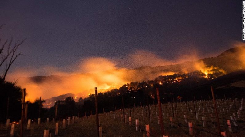 Las llamas brillan en las colinas de un viñedo en Napa, California. Al menos 15 fuegos forestales afectan la región.