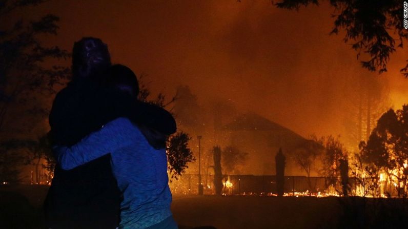 Dos mujeres se abrazan mientras ven cómo se queman las casas en Santa Rosa, California.