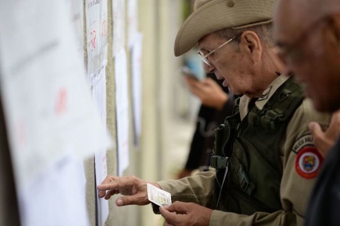 Un miembro de las milicias populares busca su nombre en las listas de votación en la municipalidad de Chacao.