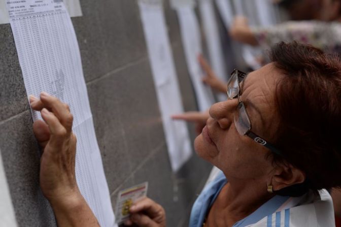 Una mujer busca su nombre en la lista electoral en una mesa de votación en la municipalidad de Chacao, en Caracas.