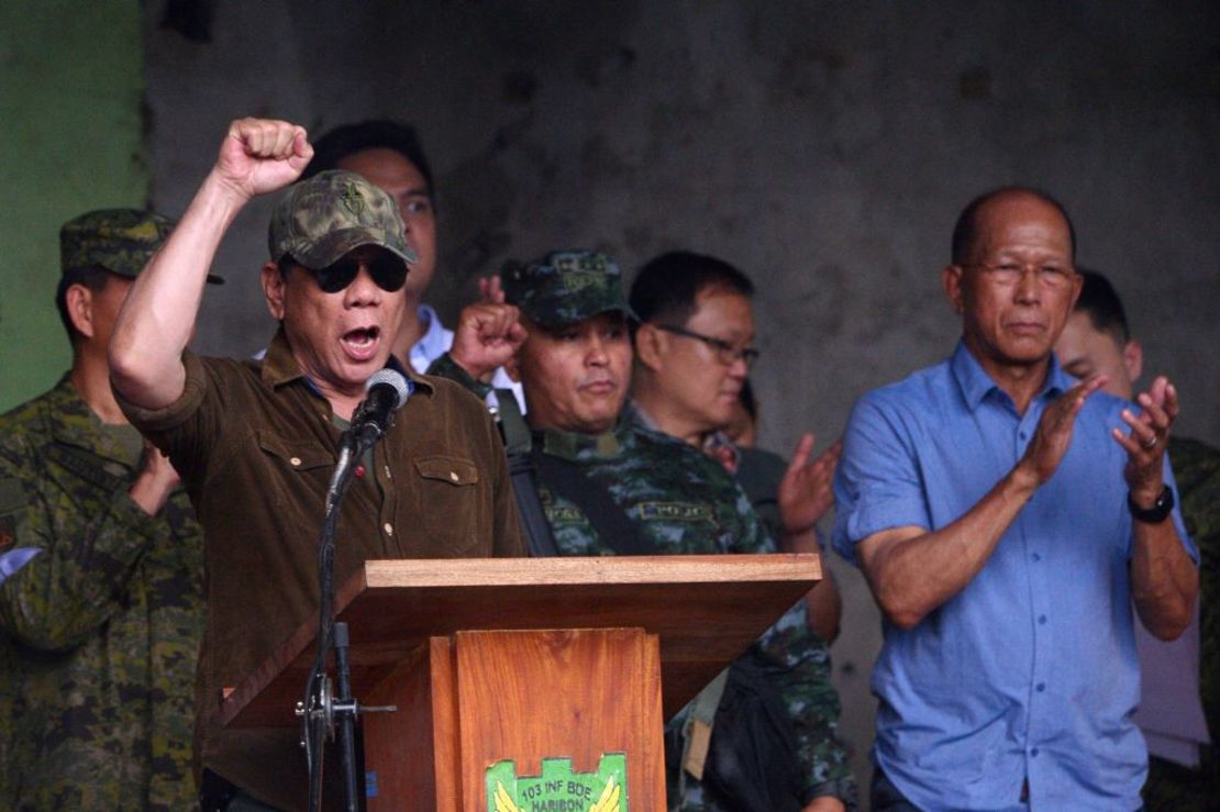 El presidente de Filipinas Rodrigo Duterte (izq.) levanta el puño al declarar la “liberación” de Marawi durante una ceremonia en el campo de batalla de Bangolo, en el distrito de Marawi, el 17 de octubre de 2017.