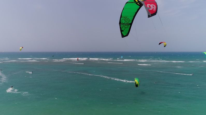 Adrenalina + estrés. Esta playa es Kite Beach, y es de renombre mundial porque aquí el pasatiempo del kitesurfing reúne a los mejores del mundo, en un día cualquiera. Aquí encuentras el cielo pintado por entre 40 y 50 surfistas. Una maravilla para fotografiar, pero que se convierte casi en una pesadilla si quieres grabarlo con un drone y, haciéndolo aún más complicado, seguir a un surfista en particular, en este caso a Luciano. La clave era no enredarnos con las pitas del "kite", porque podríamos poner en peligro la vida de los surfistas. El estrés se agranda al tener que manejar el drone con tantos elementos en movimiento, velar la ruta del drone, el viento... Era imposible saber en que dirección iban los surfistas, para no chocar contra ellos cuando saltaban sus olas. Mis respetos a mi camarógrafo Asdrúbal, que por una media hora, luchó contra todo esto. Como productora estaba claro: no había otra opción, teníamos que grabar los surfistas en plena acción, pero pensándolo bien, fui muy ambiciosa en querer esta toma. Nos tenías que ver, allí nos estábamos los tres, Asdrúbal, el asistente Daniel y yo, bajo una camiseta sudada tapándonos del sol para ver la imagen del drone en la pantalla, todo para lograr una secuencia soñada.