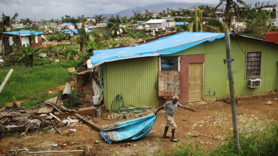 Un habitante trata de poner algo de orden en medio de los escombros dejados por el huracán en San Isidro, Puerto Rico.