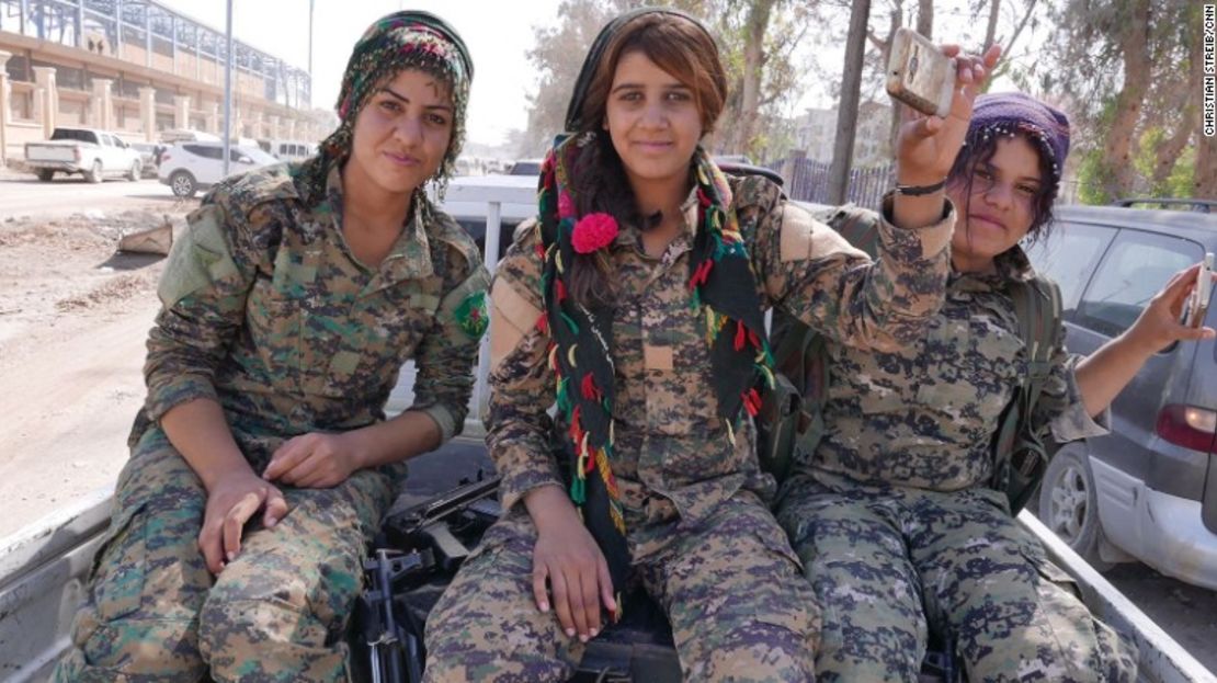 Mujeres combatientes kurdas se dirigen al estadio de Raqqa para celebrar después de la derrota de ISIS.