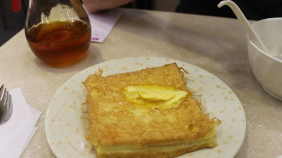 A diferencia del platillo característico y más mesurado del brunch dominical, el pan francés estilo Hong Kong es como un abrazo frito. Tomas un par de rebanadas de pan tostado y las cubres de crema de cacahuate o de mermelada de kaya, las rebosas con huevo, las fríes en mantequilla y las sirves con más mantequilla y mucho jarabe. Es uno de los mejores platillos de Hong Kong y es mejor disfrutarlo antes de que te hagas una prueba de colesterol.