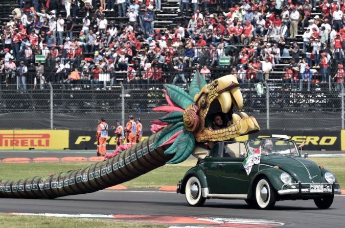 Un auto clásico decorado con detalles prehispánicos recorre la pista del autódromo mexicano antes de la carrera.