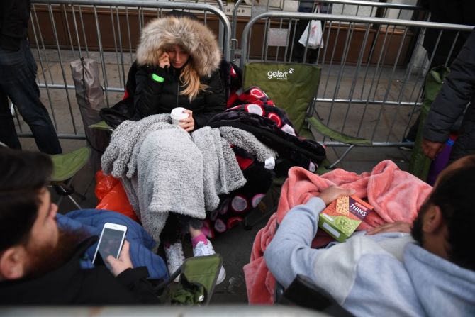 Una mujer habla por teléfono mientras hace fila para comprar el iPhone X en Londres un día antes de que saliera a la venta.