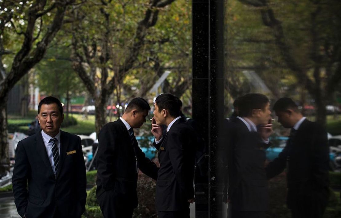 Hombres fuman frente a un edificio en Shanghai, China.