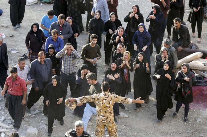 La gente se acerca a el cuerpo de un familiar fallecido en Sarpol-e Zahab.