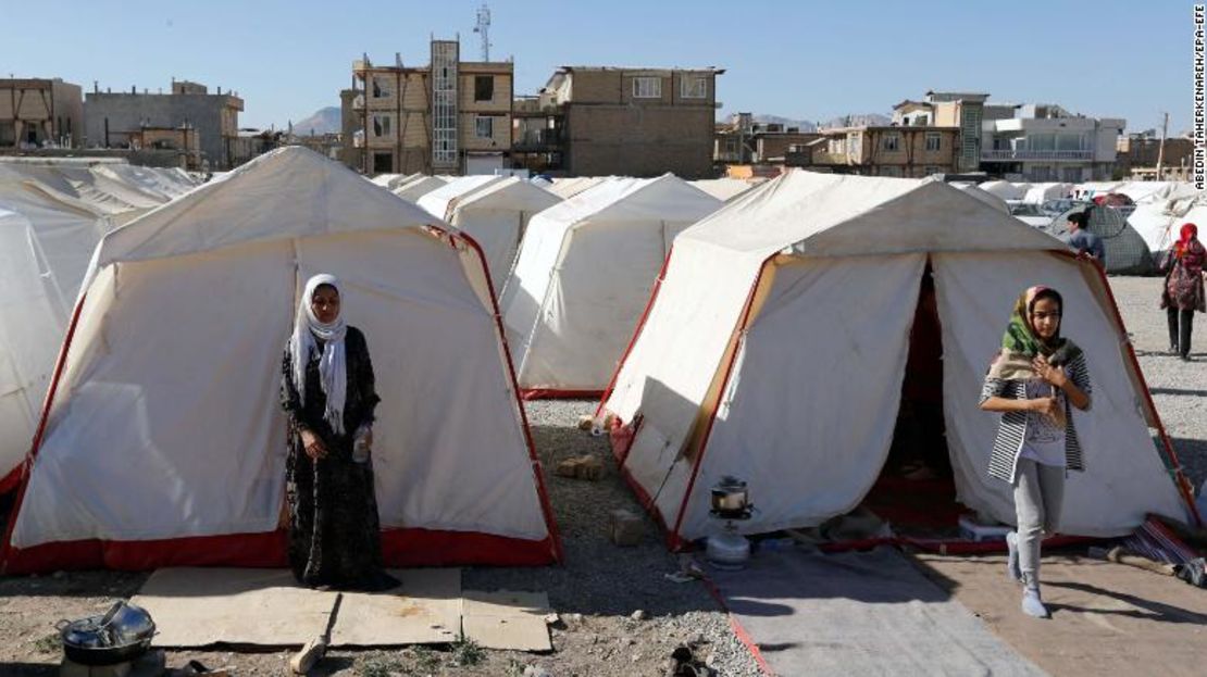 Sobrevivientes del terremoto que azotó Irán caminan alrededor de carpas de emergencia.