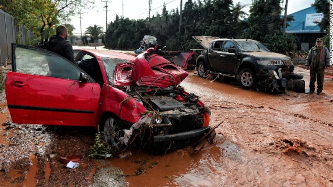 Un hombre se para cerca a un auto dañado atascado en las inundaciones en la ciudad de Mandra, al noroeste de Atenas.