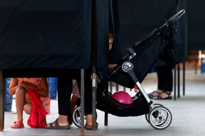 Una niña se asoma en un centro de votación en Santiago.