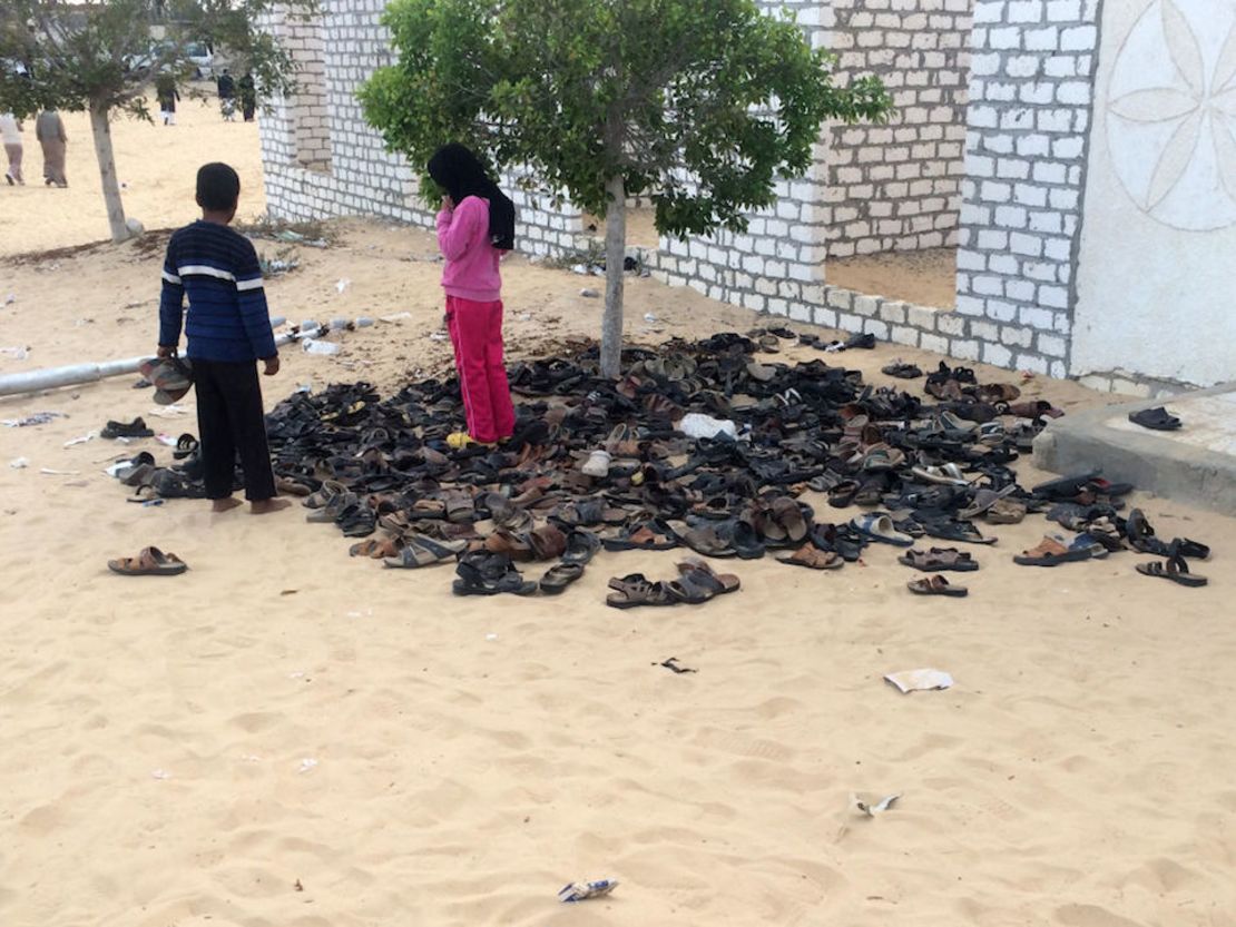 Niños egipcios junto a una pila de sandalias pertenecientes a las víctimas del ataque.