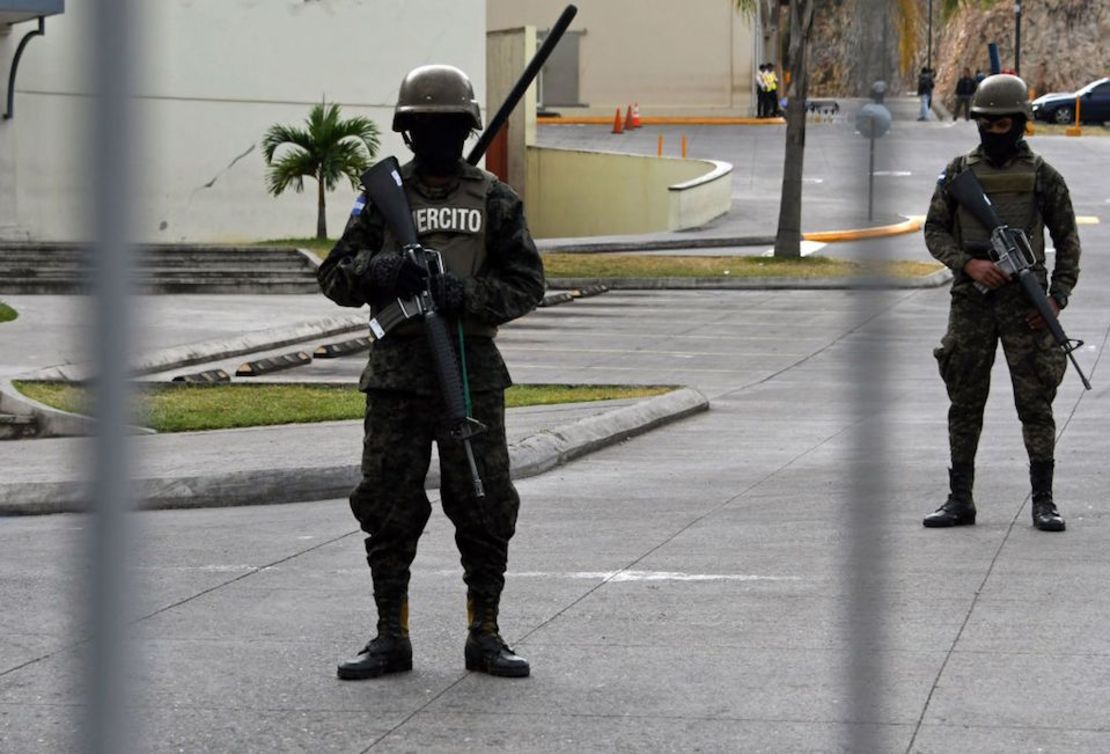 Soldados hondureños vigilan las inmediaciones de un centro comercial en Tegucigalpa un día después de que se decretara un toque de queda de 10 días tras protestas poselectorales.