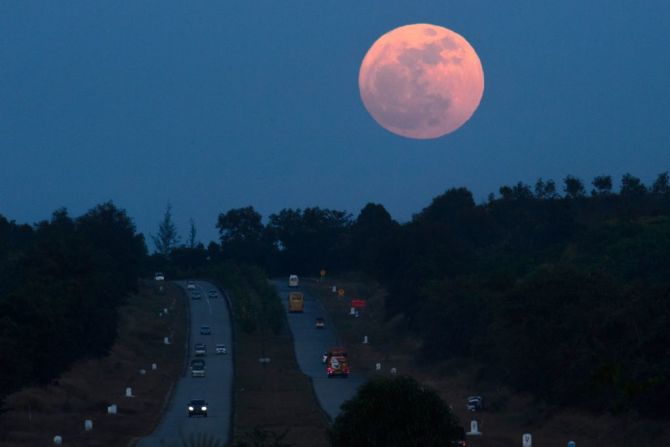 La primera y última superluna del 2017 se asoma por encima de una carretera cerca de Yangón, Myanmar.