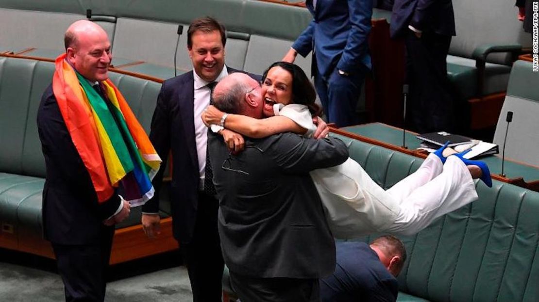 El parlamentario liberal Warren Entsch alza a la laborista Linda Burney con quien trabajó conjuntamente para pasar la ley de matrimonio igualitario en la Cámara del Parlamento en Camberra, Australia, este 7 de diciembre.