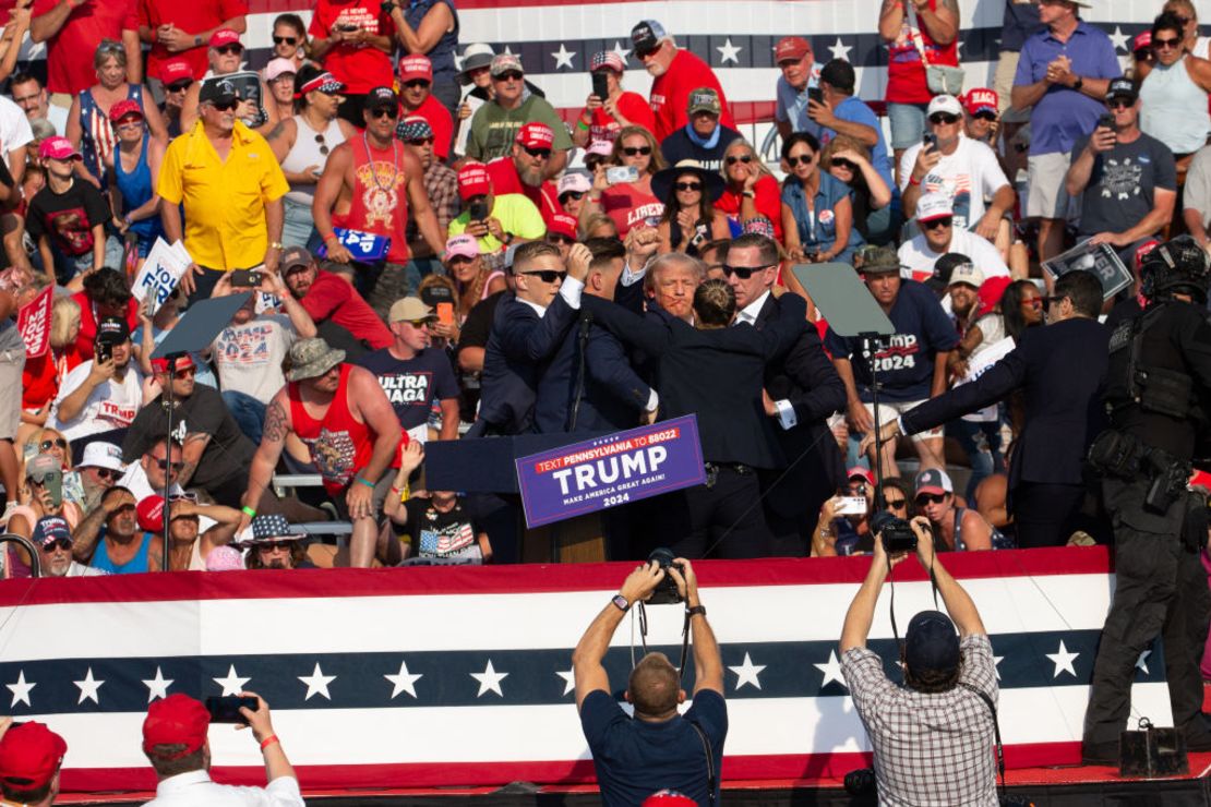 El candidato republicano Donald Trump es visto con sangre en el rostro rodeado de agentes del servicio secreto mientras lo sacan del escenario en un evento de campaña en Butler Farm Show Inc. en Butler, Pensilvania, el 13 de julio de 2024. (Foto: REBECCA DROKE/AFP vía Getty Images).