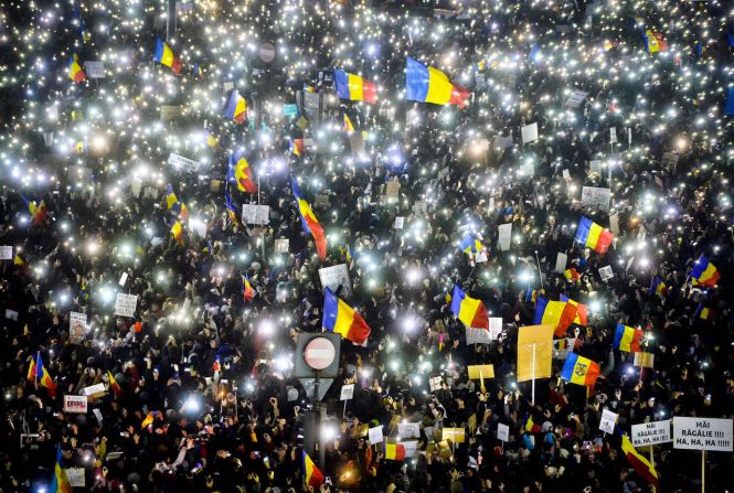 5 de febrero — Un grupo de manifestantes hacen alumbrar sus teléfonos celulares durante una protesta frente al edificio de gobierno de Bucarest en Rumania. Medio millón de personas se tomó las calles para protestar por un proyecto de ley que habría evitado que muchos políticos fueran investigados por corrupción. El gobierno anunció ese día que derogaba el decreto, que había sido aprobado sin la participación del Parlamento.