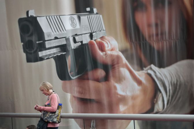 29 de abril — Una mujer camina junto a un gran afiche, en la convención anual de la Asociación Nacional del Rifle. Este año, el evento se realizó en Atlanta.