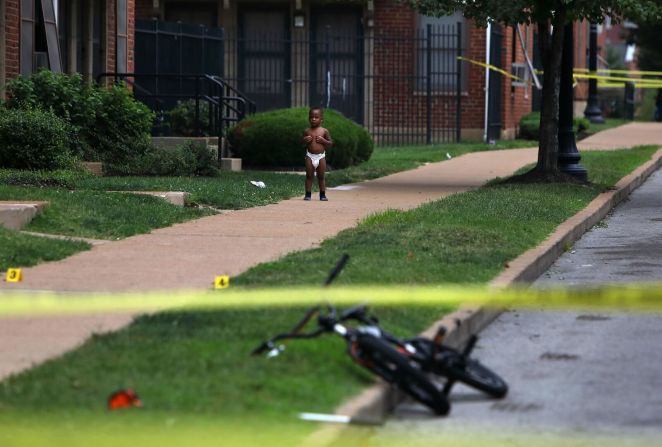 7 de agosto — Un niño a las afueras de una casa en St. Louis, Missouri, donde la policía local investiga la escena de un mortal tiroteo.