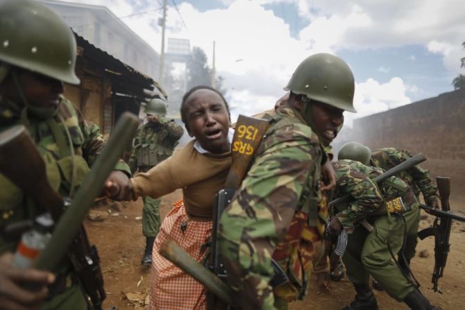 30 de octubre - Un policía lleva en su espalda a una niña de colegio en Nairobi, Kenya, afectada por el gas lacrimógeno en medio de los enfrentamientos por la incertidumbre de las elecciones.