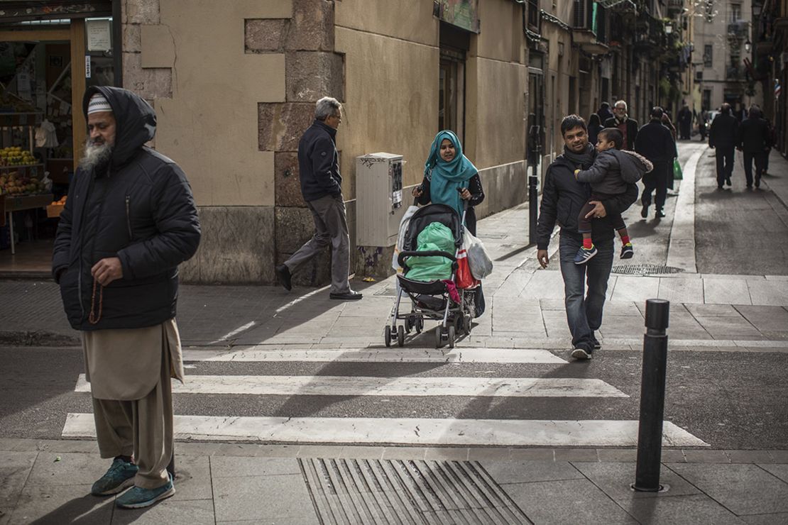 Un grupo de personas cruza la calle en el vecindario de El Raval, en Barcelona. Más de la mitad de residentes que viven en este barrio son de fuera de España.