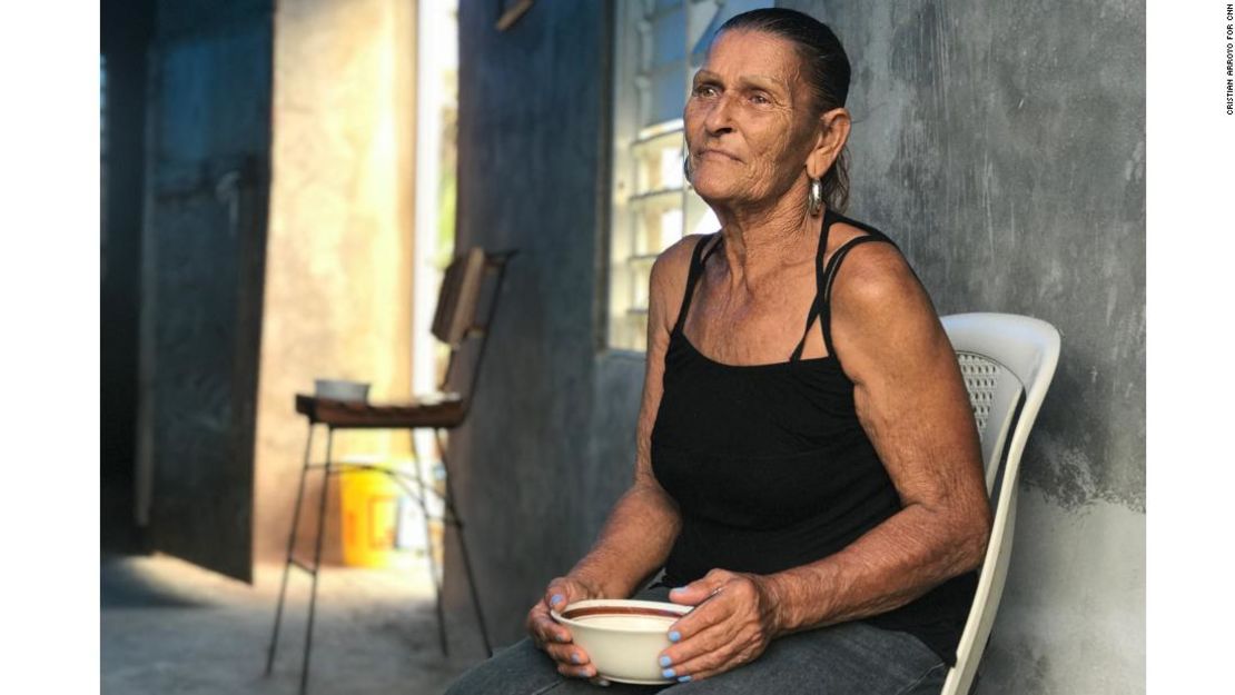 Paula Morales almuerza bajo la lona de emergencia proporcionada por el gobierno, en su casa que quedó sin techo, en Yabucoa.