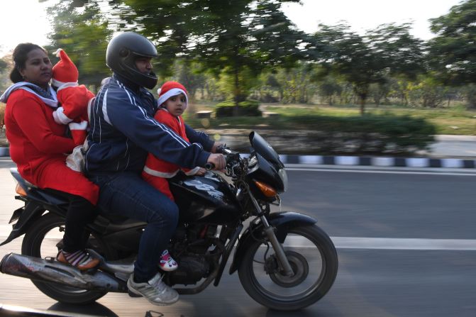 India: una familia con niños vestidos como Santa Claus monta una motocicleta en Nueva Delhi.