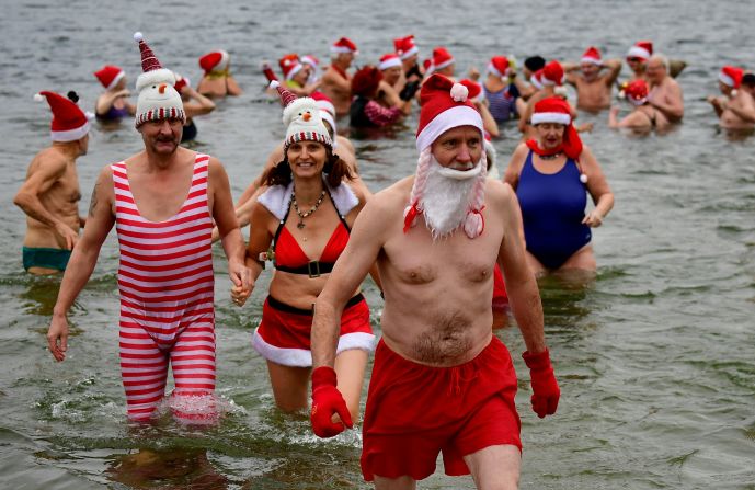 Alemania: miembros del club de natación Berliner Seehunde ("Focas de Berlín") toman un baño en el lago Oranke, durante su tradicional fiesta navideña en la capital de Alemania.