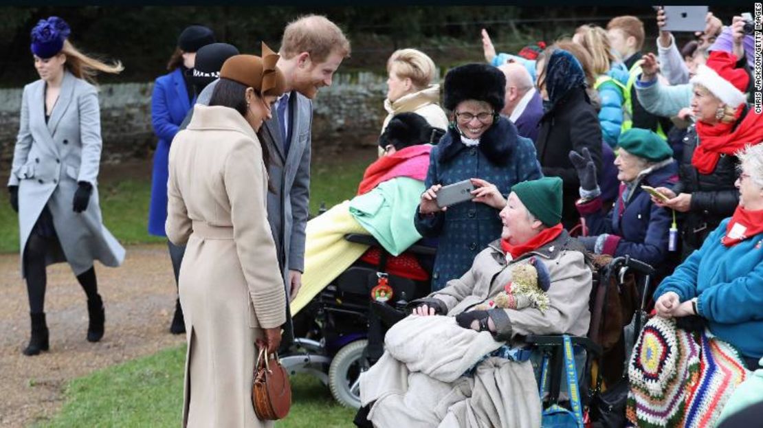 Meghan Markle y el príncipe Enrique saludan a un grupo de personas a las afueras de la iglesia.