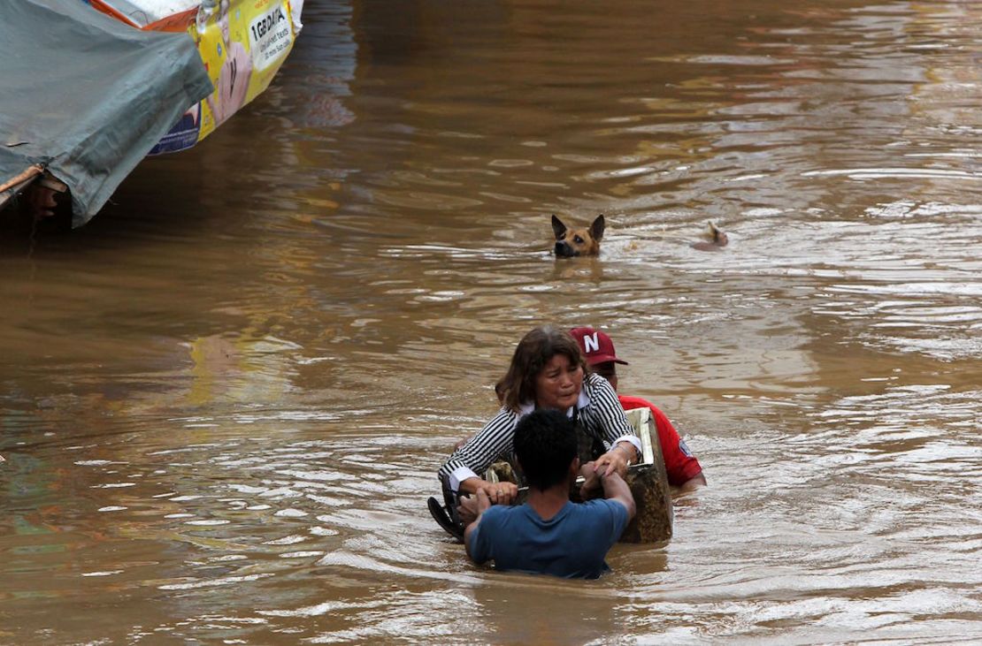 Residentes reman por una calle inundada en la ciudad de Cagayan el 22 de diciembre luego de que río Cagayan se desbordara por las fuertes lluvias que dejó el tifón Tembin.