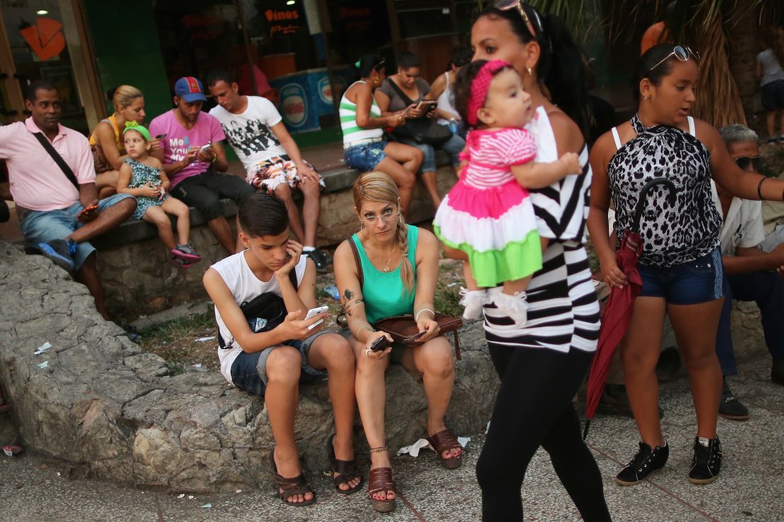 Los cubanos se reúnen al aire libre para utilizar un punto de acceso inalámbrico a Internet, a lo largo de La Rampa, un distrito de arte, entretenimiento y negocios en el Vedado, 13 de agosto de 2015 en La Habana, Cuba.