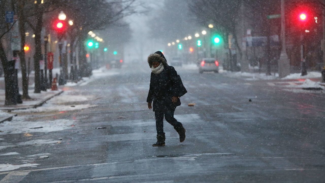 Una persona camina por la calle vacía de Boston durante la tormenta de nieve. Escuelas y negocios en todo EE.UU. han sido cerrados por el frente frío.