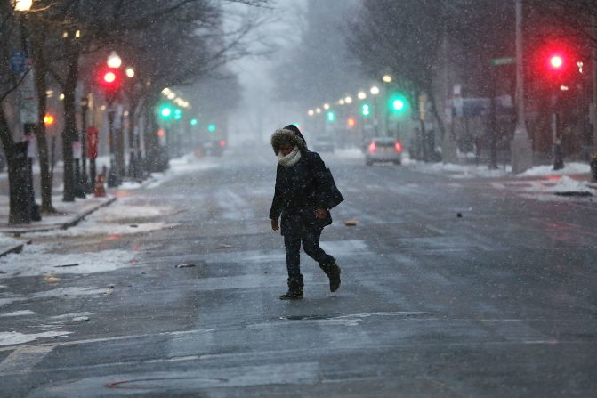 Una persona camina por la calle vacía de Boston durante la tormenta de nieve. Escuelas y negocios en todo EE.UU. han sido cerrados por el frente frío.