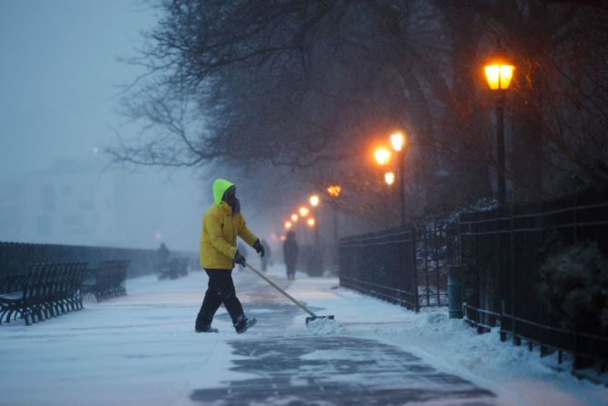 Un trabajador palea la nieve en Nueva York.