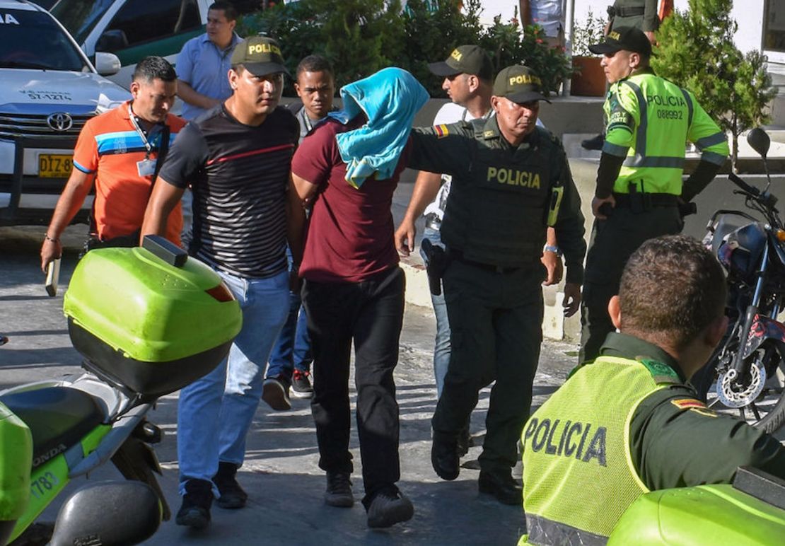 Policías escoltan a un sospechoso del ataque en Barranquilla.