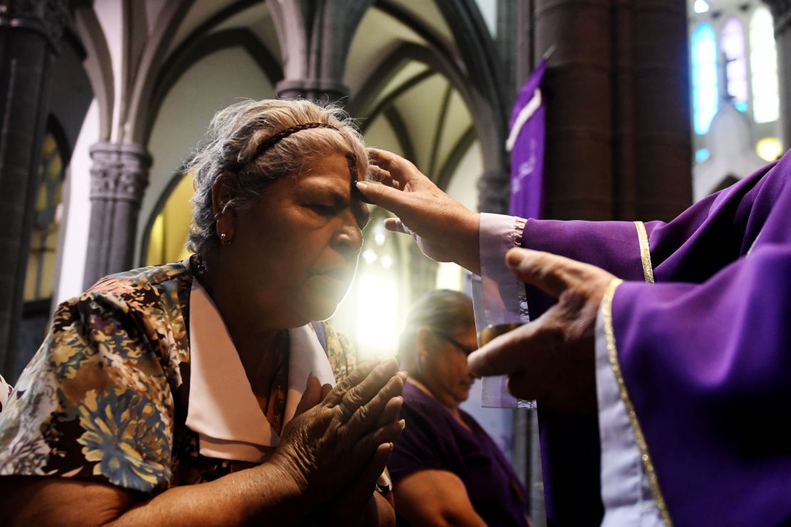 Una mujer recibe la señal de la cruz durante una misa el Miércoles de Ceniza en San Salvador.