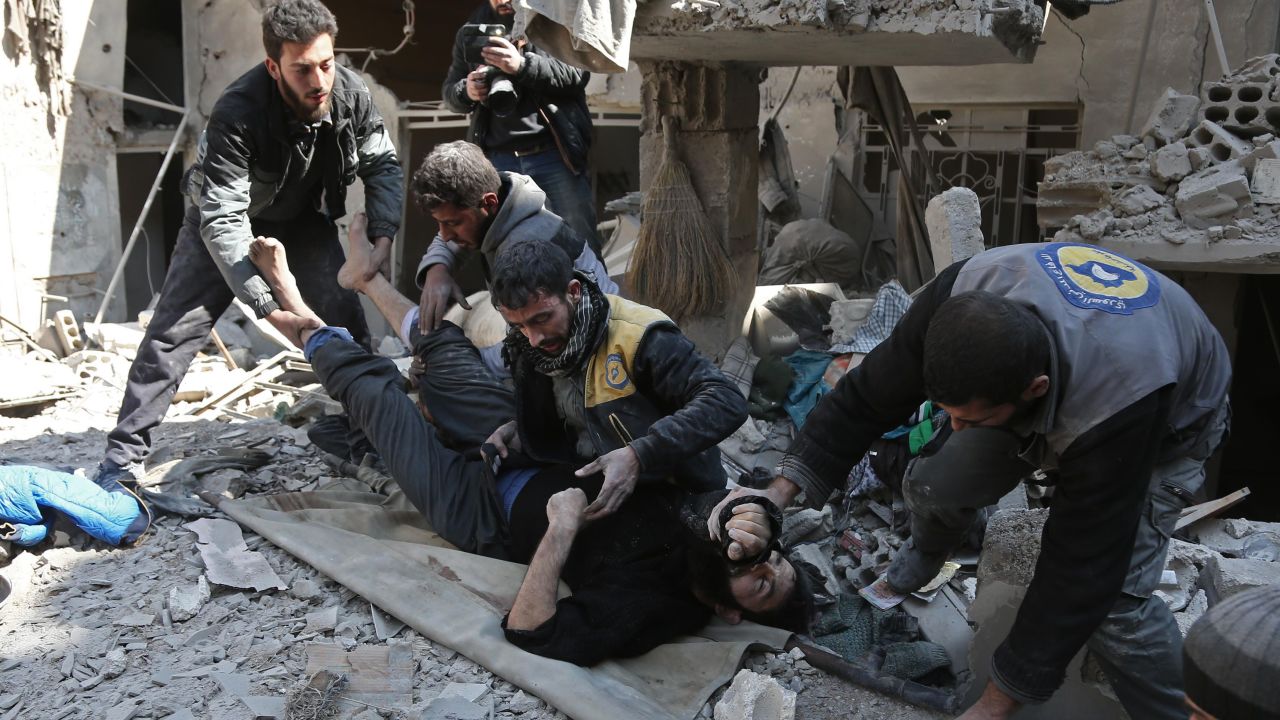 Miembros de Defensa Civil siria rescatan a un hombre de los escombros de un edificio.