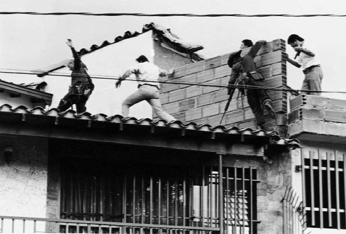 Fuerzas policiales y militares colombianas asaltan la azotea donde el narcotraficante Pablo Escobar había sido dado de baja hacía unos minutos durante un intercambio de disparos entre las fuerzas de seguridad, Escobar y su guardaespaldas el 2 de diciembre de 1993.