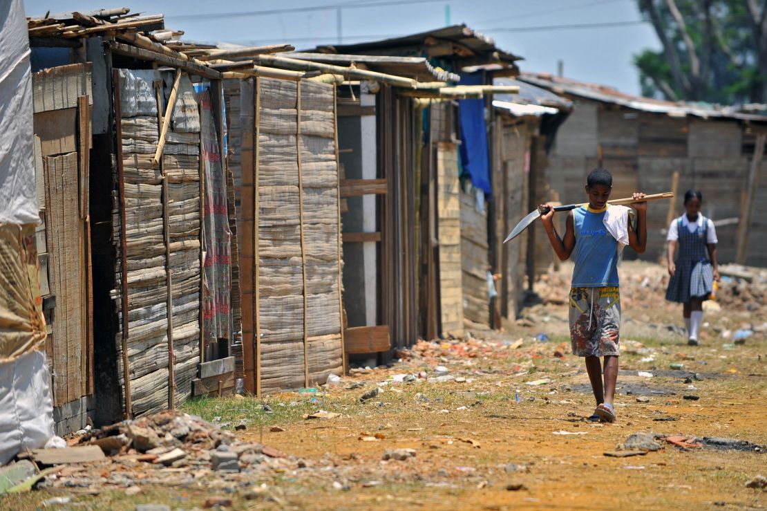 CNNE 501015 - a young man walks carrying a shovel next