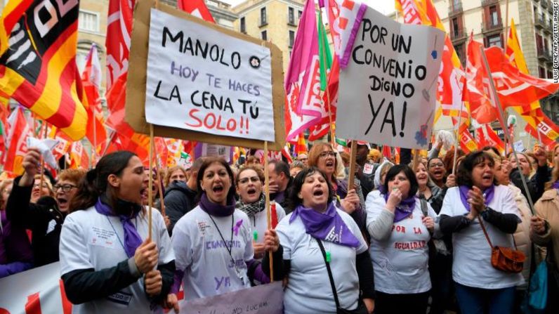 Manifestantes sostienen una pancarta que dice "Manolo, hoy te haces la cena tu solo" durante la huelga de un día en Barcelona.