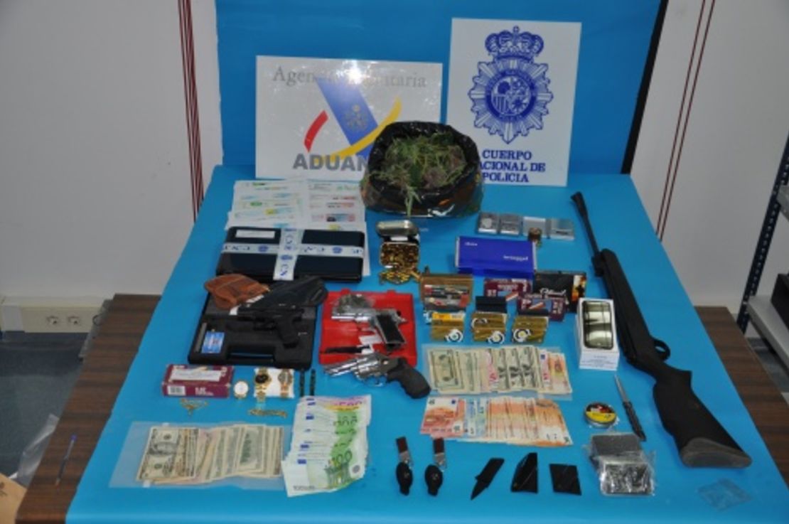 Dinero y armas incautadas a los 14 detenidos por presunta explotación sexual.